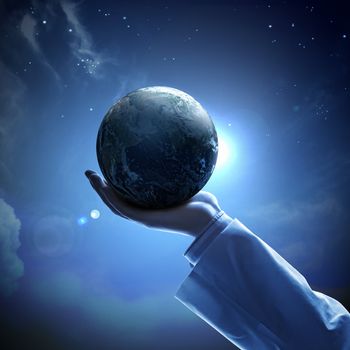 Hand of businessman holding earth planet against illustration background