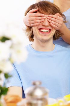 Young couple at home together - closing partner's eyes