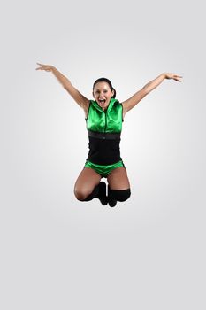 Young female dancer jumping against white background