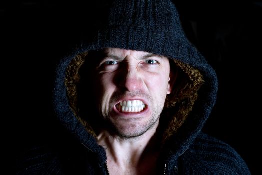 angry violent man with hood up screaming