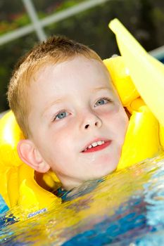 little boy swimming with life vest on