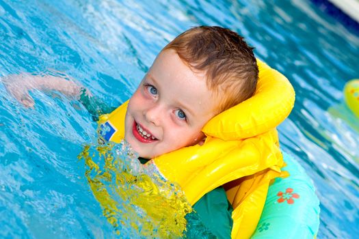 little boy swimming with life vest on