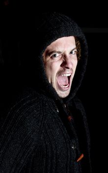 angry violent man with hood up screaming