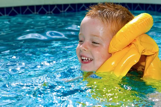 little boy swimming with life vest on