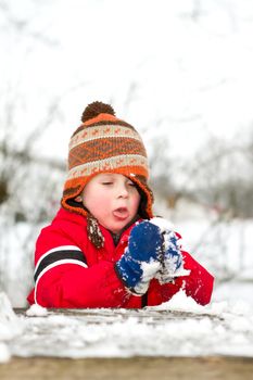 young boy building a snow ball