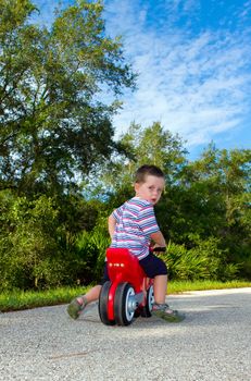 boy riding on a toy motorbike