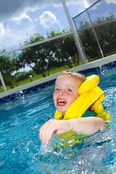 little boy swimming with life vest on