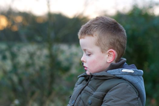 depressed young child outside in field