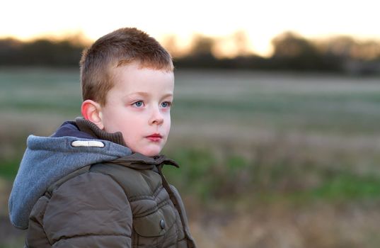 sad young boy in a field