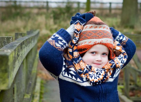 cheeky boy playing with his winter hat