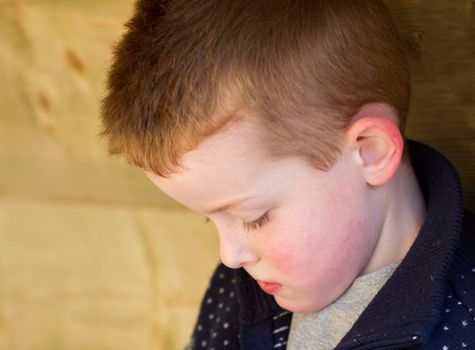 Depressed young boy looking down to the floor