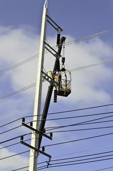 Electrical repairs by electricians on a power pole
