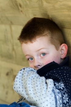 young boy peeking from behind his clothing