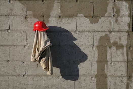 Construction worker taking a lunch break. Hard hat and jacket hanging on the wall making a nice shadow.