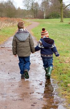 brothers holding hands on a country path