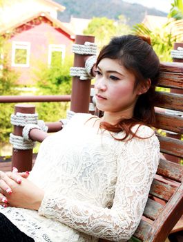 asian young woman resting on a wooden chair