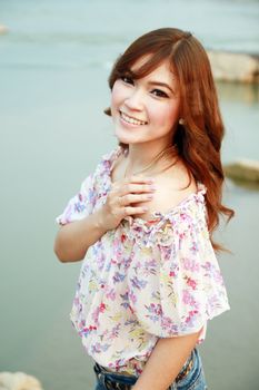 a portrait of beautiful woman with river background