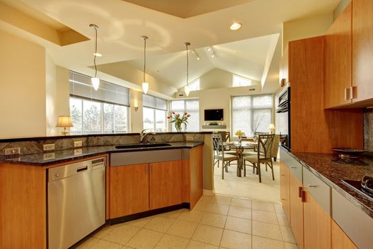 Large modern wood kitchen with living room and high ceiling and ivory walls.