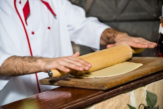 Cook rolls out the dough on a board, the traditional cooking