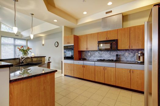 Large modern wood kitchen with living room and high ceiling and ivory walls.