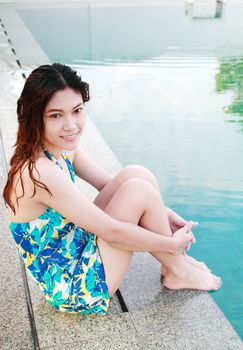 Woman sitting at the Edge of a Swimming Pool