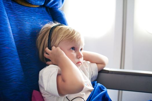 small child with headphones in the plane