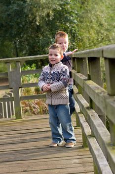 Brothers looking out across a pond in Autumn