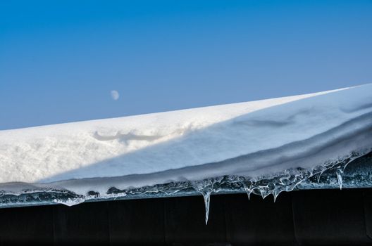 snow and icicle at a roof in winter