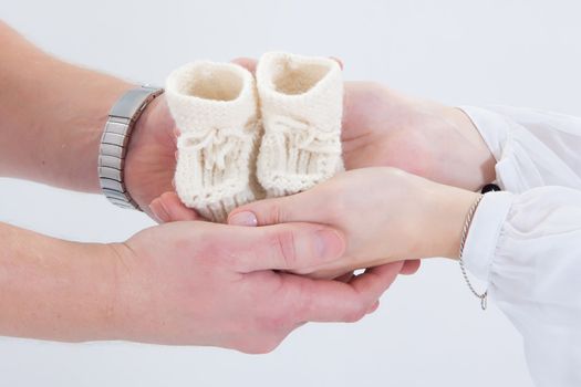 Parents holding self-made child's boots in their hands. 