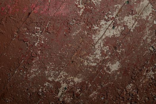 Diagonal timbers with layers, of old red flaking paint in a variety of tones.