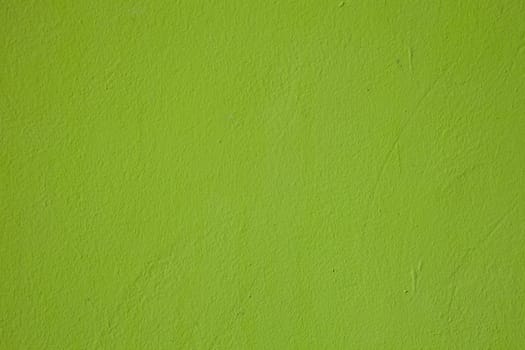 A light shade of lime green paint on a rendered surface.