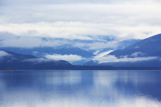 scenic mountain blue lake lanscape with the morning mist and clouds