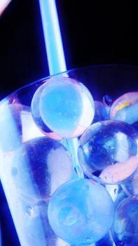 a very cold cocktail with many ice balls and a drinking straw.