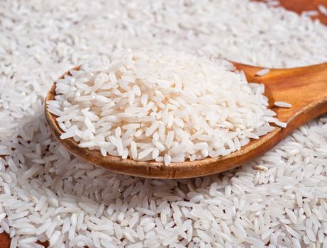 Rice background with wooden spoon.