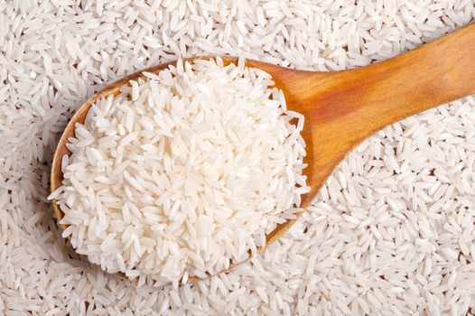 Rice background with wooden spoon.