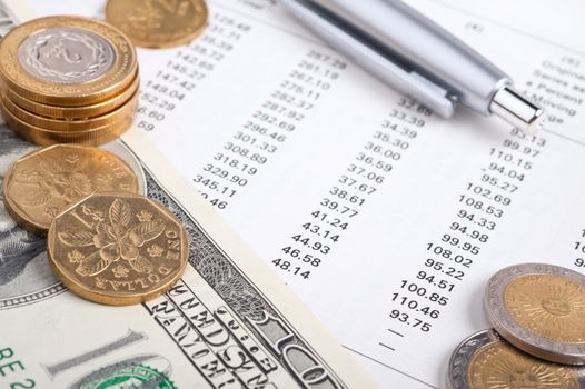 Business diagram on financial report with coins and dollars.