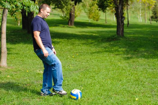 Young man playing football on green grass