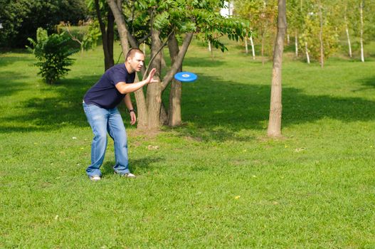 Young man playing frisbee on green grass