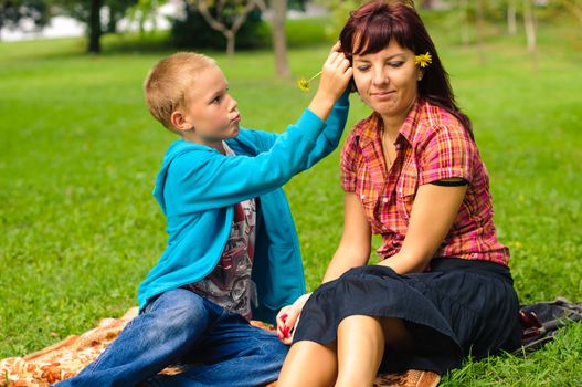 Mother and son play outside on field in the park