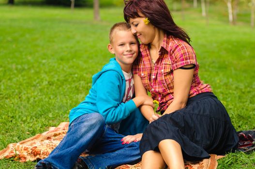 Mother and son play outside on field in the park