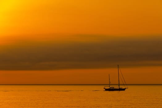 Dawn sailboat silhouette on ocean