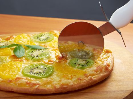 homemade sweet pizza with fruit.Closeup  a knife cut the pizza 