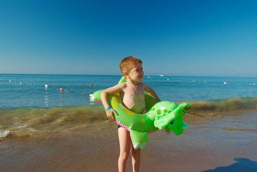 Little boy in the waves on the sea beach