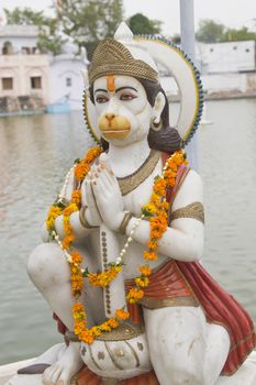 Durgiana Hindu Temple. Marble statue of religious deity garlanded in orange flowers. Amritsar, Punjab, India