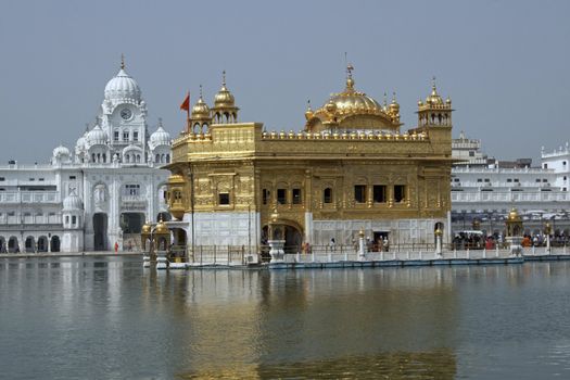 Golden Temple. Holiest shrine of the Sikh religion. Ornate gold covered building in the middle of an artificial lake in Amritsar, Punjab, India.