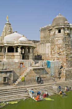Indian women washing clothes in the lake of a derelict palace (Pratap Palace) inside Chittaugarh Fort in Rajasthan, India