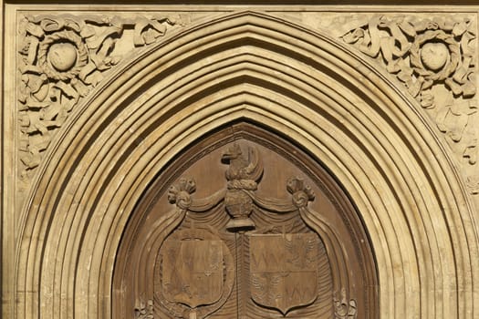Large wooden door set in the west front facade of Bath Abbey. 16th Century church, Bath, England, United Kingdom