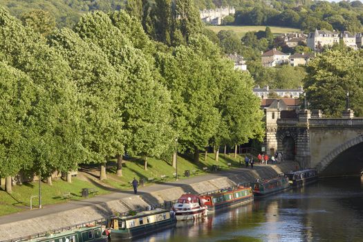 Canal boats moored on the River Avon in the centre of the historic city of Bath in Somerset, England