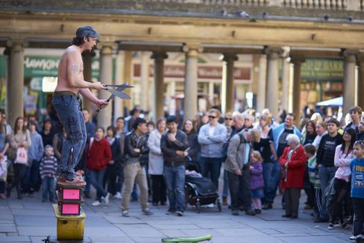 Street artist juggling with knives in Abbey Churchyard, Bath, Somerset, England