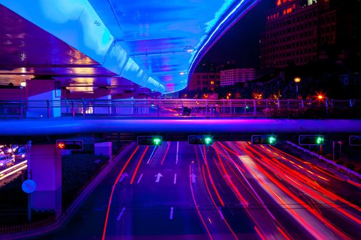 Blue Highway Street Traffic Cars and Green Traffic Light Red Light Trails at Night in Central Shanghai, China.